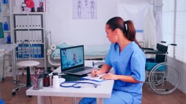 Uzaktan kumandalı doktorun tavsiyelerini dinleyen bir asistan.