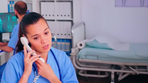 Медицинский рентгенолог отвечает на звонки пациентов по телефону — стоковое видео