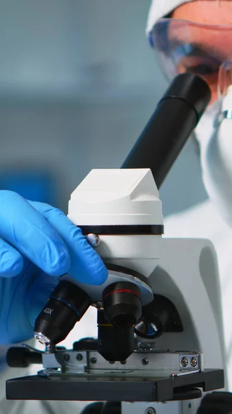 Крупный план врача-химика, анализирующего вирус с помощью микроскопа — стоковое фото