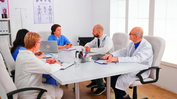 Equipo de médicos expertos que tienen una sesión informativa en la sala de conferencias del hospital — Foto de Stock