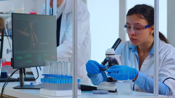 Mujer científica haciendo investigación usando microscopio —  Fotos de Stock