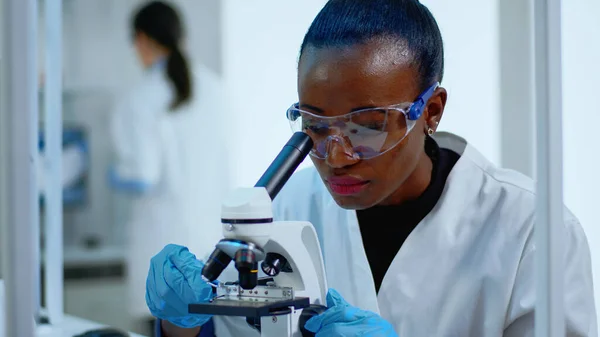 Close up of black woman looking in microscope — Stock Photo, Image