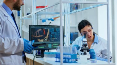 Tıbbi ekip bilim adamı dijital mikroskop altında DNA deneyleri yapıyor.