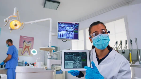 Patiënt gezichtspunt in tandheelkundige kantoor bespreken behandeling van tanden met behulp van tablet — Stockfoto