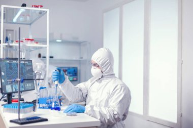 Modern laboratuardaki kimyager dağıtıcı kullanarak araştırma yapıyor.