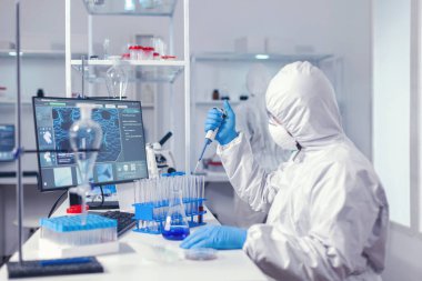 Laboratuvar otomatik pipet ve test tüpleriyle çalışıyor.