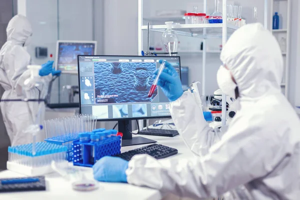 Вчений в лабораторії тримає трубку з зразком крові — стокове фото