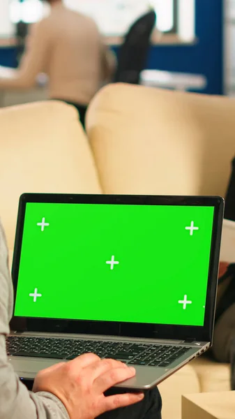 バックビジネスマンのビューは、緑の画面とノートパソコンを使用してソファに座って — ストック写真