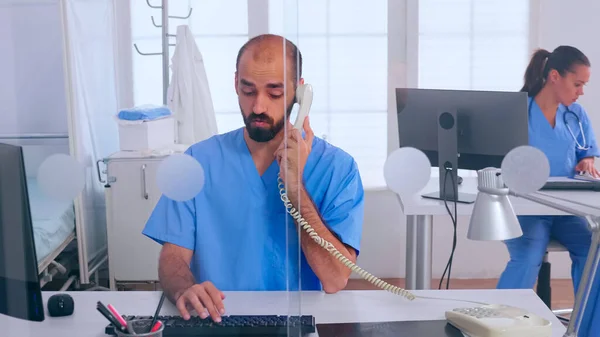Medicinska receptionister som arbetar på sjukhuskliniken och svarar i telefon — Stockfoto
