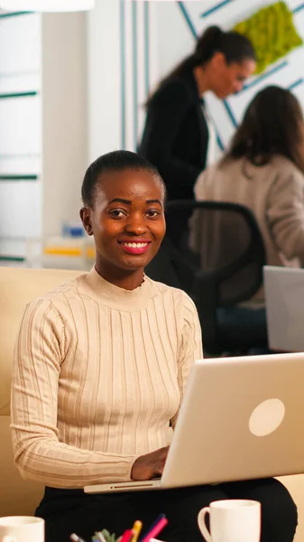 Retrato de mulher africana digitando no laptop olhando para a câmera sorrindo — Fotografia de Stock