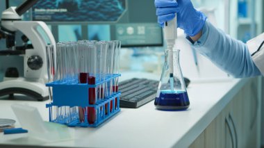 Mikro pipet kullanarak sıvı örneklerini test eden bilim adamlarını kapat