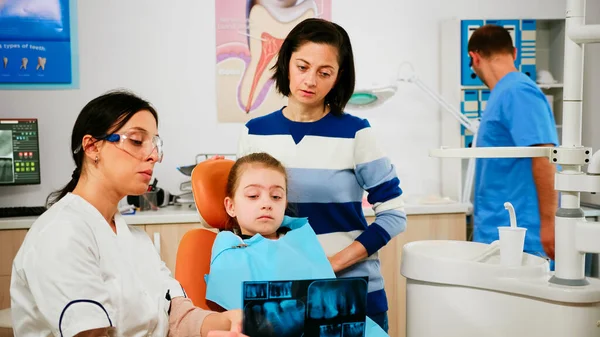 Pediatrický zubař ukazující zubní problémy s radiografií — Stock fotografie