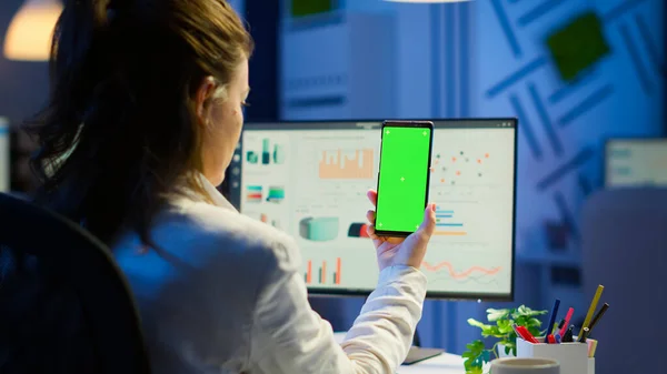 Bakåt bild av affärskvinna tittar på smartphone med grön skärm — Stockfoto