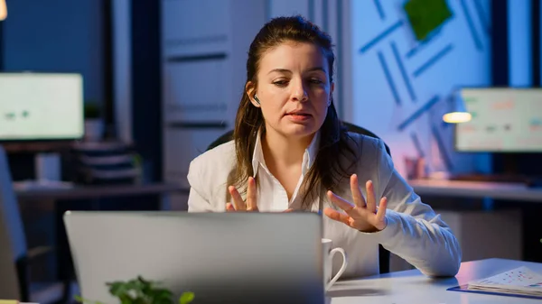 Business woman using wireless headphone duing video conference — Stock Photo, Image