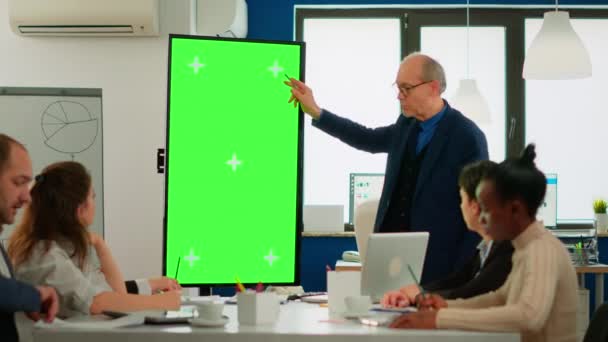 Ώριμος επιχειρηματίας που αναλύει αναφορές που στέκονται στην αίθουσα συνεδριάσεων δείχνοντας την οθόνη πράσινης οθόνης — Αρχείο Βίντεο