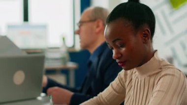 Siyahi kadın kameraya bakıp gülümsüyor.