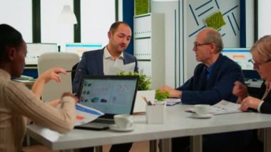 Takım elbiseli bir işadamı farklı iş ortaklarıyla konuşuyor.