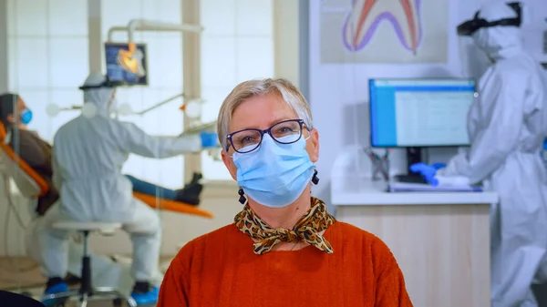 Retrato de paciente aposentado com máscara em consultório odontológico olhando para a câmera — Fotografia de Stock