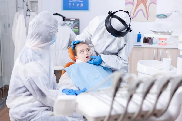 Mała dziewczynka ubrana w strój ppe podczas wizyty stomatologicznej — Zdjęcie stockowe