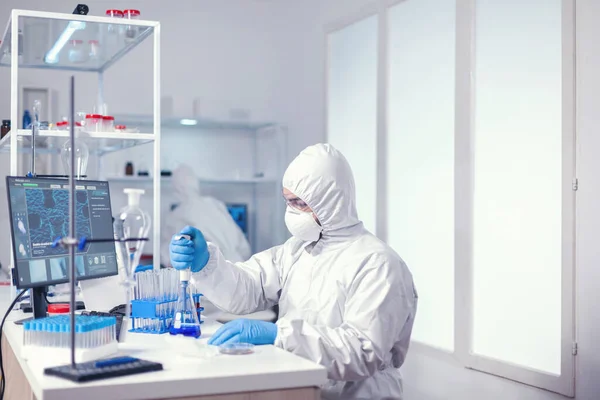 Mikrobiolog klädd i coverall med automatisk pipett — Stockfoto