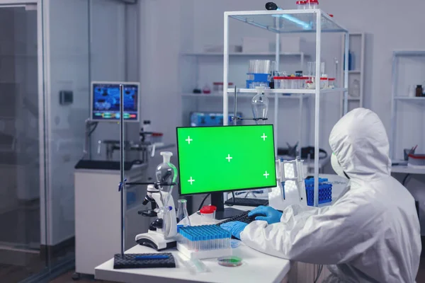 Pesquisador médico digitando no teclado do computador com tela verde — Fotografia de Stock