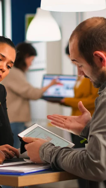 Close up of diverse business team checking graphs from tablet making new strategy. — Stock fotografie