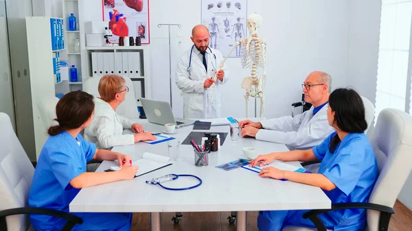 Expert doctor analysing radiography using human skeleton — Foto de Stock