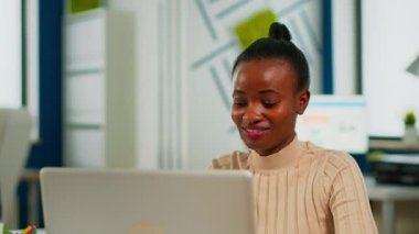 Afro-Afrikalı iş kadınının portresi dizüstü bilgisayardan iyi haberler okuyor.