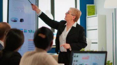 Dijital proje sunumunu analiz eden ciddi üst düzey yönetici ve çeşitli takım çalışanları