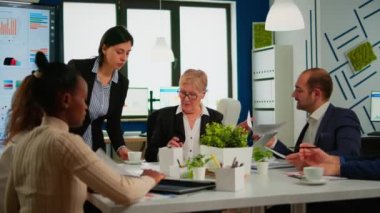 Kadın sekreter idari müdüre belge ve kahve getiriyor.