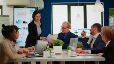 Buluşmak için belgeleri kullanan çok ırklı insanlardan oluşan zeki bir ekip.