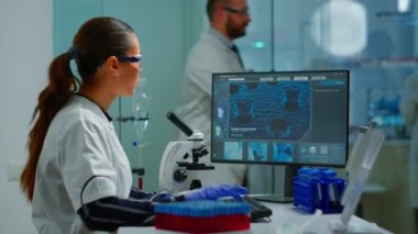 Biyoteknoloji bilim adamı mikroskop kullanarak laboratuvarda araştırma yapıyor.