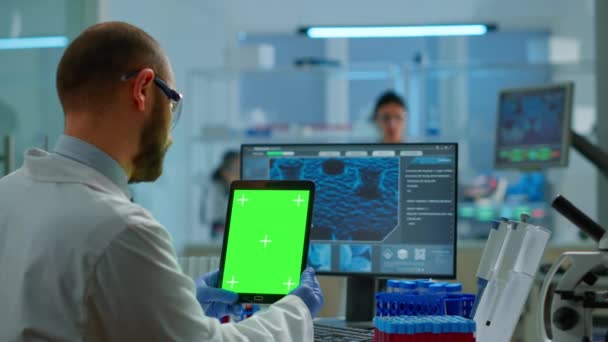 近代的な設備の整った研究室で緑の画面でタブレットを保持男医師 — ストック動画