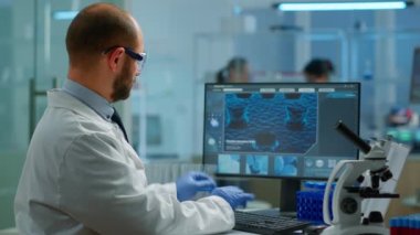 Laboratuvar önlüklü bilim adamı test tüpündeki kan örneğini analiz ediyor.