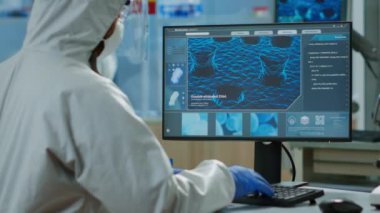 Bilgisayarda aşının evrimini analiz eden kimyagerin arka plandaki görüntüsü.