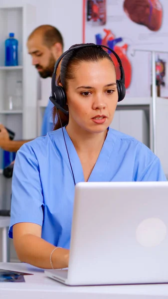 Medical assistant operator with headphone consulting patients