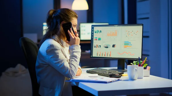 Gerente nervioso discutiendo en el teléfono inteligente con el empleado trabajando horas extras — Foto de Stock