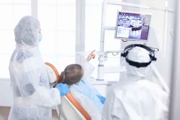 Little girl in ppe suit pointing at digital radiography