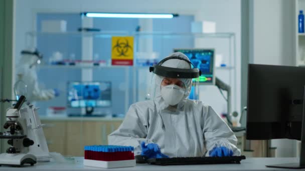 Scientist in coverall examining blood test tubes at laboratory DNA testing analysis — Stock Video