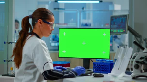 Kobieta naukowiec wpisując na komputerze z zielonym ekranie mockup wyświetlacz — Wideo stockowe