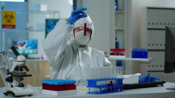Дослідник з укриття, що тримає пробірки з аналізом крові — стокове відео