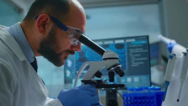 Laborant vyšetřující vzorky a kapalinu pomocí mikroskopu — Stock video