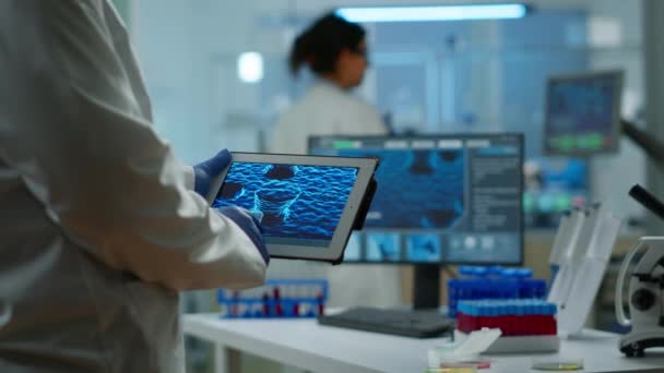 Primo piano dello scienziato in camice da laboratorio che lavora tenendo tablet — Video Stock