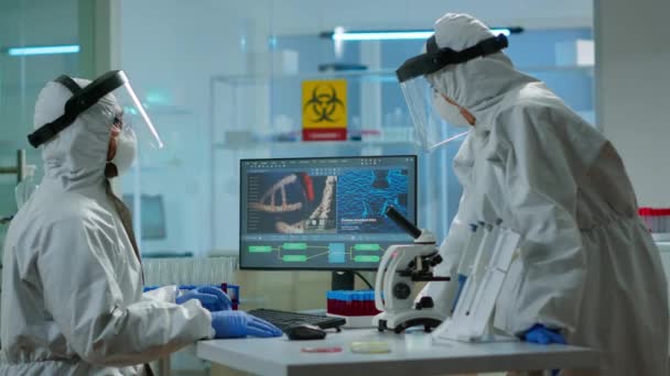 Вчений біотехнології в костюмі піп досліджує в обладнаній лабораторії — стокове відео