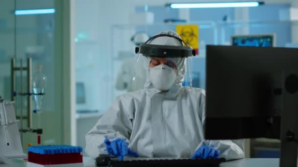 血液サンプルを分析するパイプスーツの研究室の技術者アシスタント — ストック動画