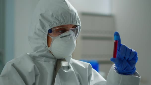 Cientista em macacão fazendo pesquisa analisando líquido em tubo — Vídeo de Stock