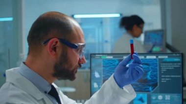 Viorolog araştırmacısı test tüpünden alınan kan örneğini inceliyor.