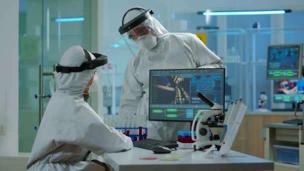 Команда вчених у костюмі прорізування сперечається перед ПК, дивлячись на розвиток вірусу — стокове відео
