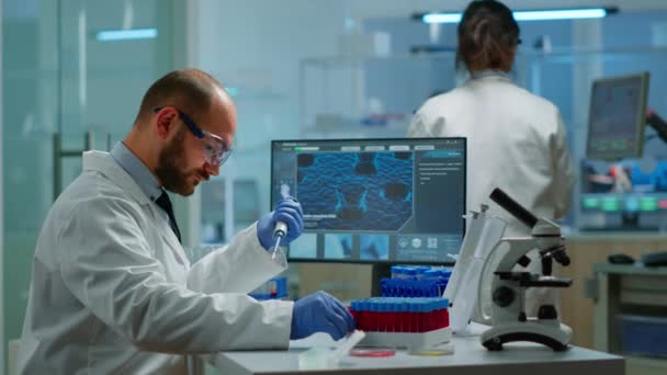인간 과학자들이 현대 시설을 갖춘 실험실에서 시험관을 채우기 위해 마이크로 피펫을 사용하는 모습 — 비디오