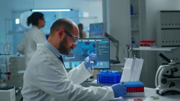 Naukowiec badający odkrycie leku umieszczając próbkę krwi w szalce Petriego z mikropipetą. — Wideo stockowe